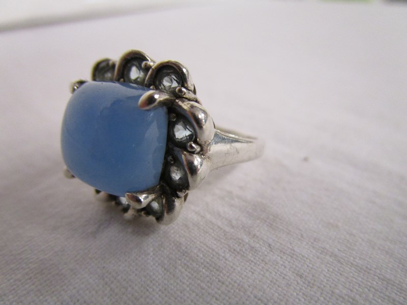 Silver ring set with blue cabochon and pale blue stones