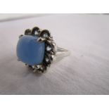 Silver ring set with blue cabochon and pale blue stones