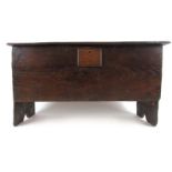 An 18th century oak six plank coffer, the top lifting to reveal a vacant interior with candle box,