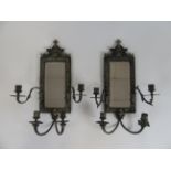 A near pair of early 20th century cast silvered brass wall mirrors,