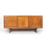 A 1970's walnut sideboard, the four drawers bedside a pair of doors on a sleigh base, l.