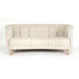 A 1970's and later bow fronted two seater sofa with cream classical upholstery on beech legs