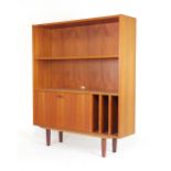 A 1960/70's teak open bookcase, the adjustable shelf over a fall front and LP slots,