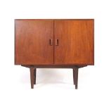 A 1960's Danish teak two door cabinet with triangular handles and a beech interior on square