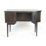 A 1970's Danish stained oak desk, the dome shaped surface with three drawers and a tambour door,