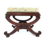 An early 19th century rosewood x-framed stool with a floral buttoned fabric seat over moulded legs