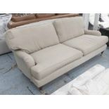 SOFA, two seater, Howard style in beige fabric on turned castor supports, 212cm L.