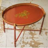 TRAY TABLE, Italian red and gilt metal in Fornasetti style, of oval form on folding stand,