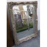 MIRROR, bevelled in an ornate silver painted frame, 110cm x 79cm.