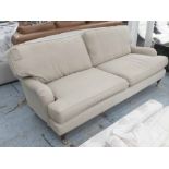 SOFA, two seater, Howard style, in beige fabric on turned castor supports, 212cm L.