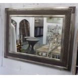 WALL MIRROR, decorative silvered frame enclosing a plate, 121cm W x 94cm H.