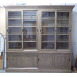 LIBRARY BOOKCASE, having shelves with sliding glazed doors, lower sliding panelled doors below,