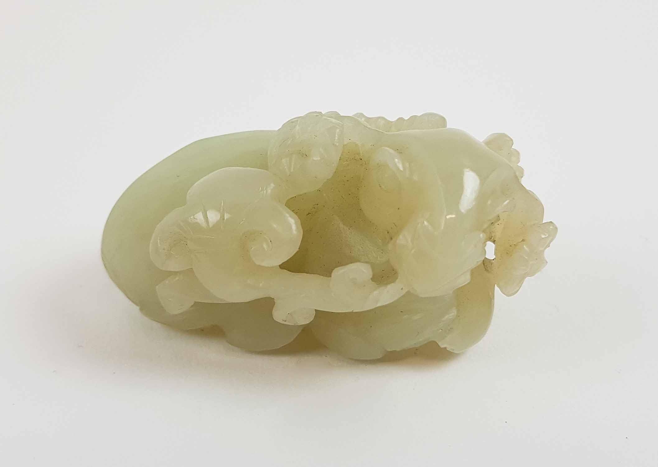 A CHINESE PALE CELADON COLOURED JADE FIGURE, of a recumbent ram, 6cm Long.