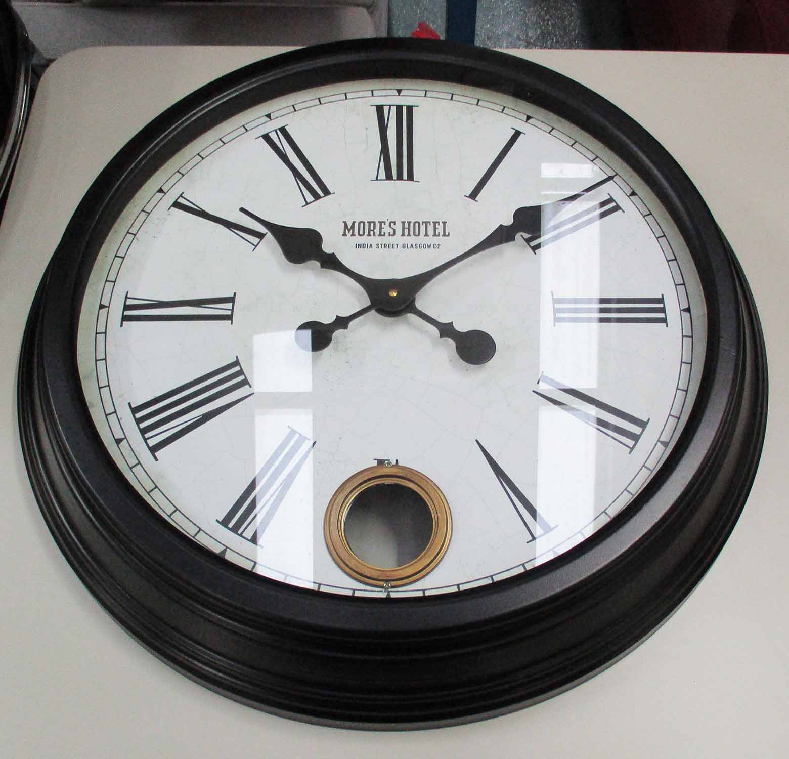 WALL CLOCKS, a pair, with Roman numerals in a black metal frame, 58cm diam.