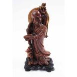 SOAPSTONE FIGURE, man with foo dog, carved wooden stand, 19cm H overall.