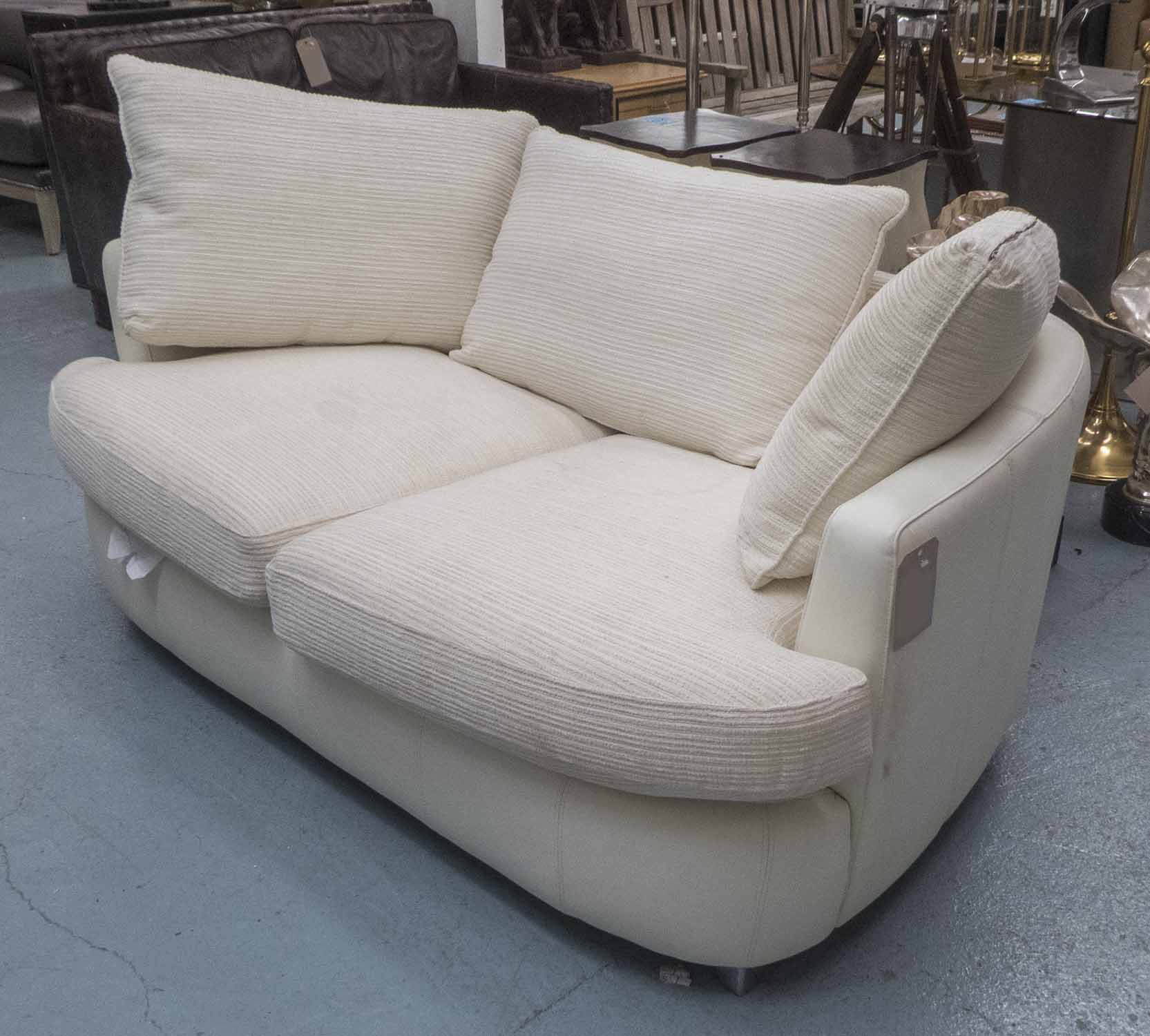 SOFA, two seater, in cream leather and cream fabric on metal supports, 172cm long.