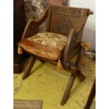 GLASTONBURY CHAIR, early 20th century oak, with decorative panel and carved back bears monogram,