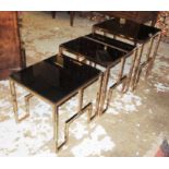 NEST OF TABLES, a set of three graduated copper coloured framed, each with a black glass top,