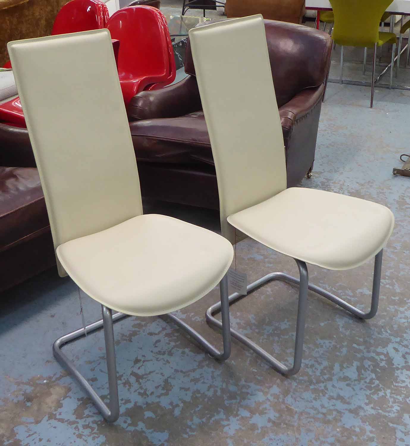 DINING CHAIRS, by Liquid Concept, a set of six, cream stitched leather on tubular metal frames.