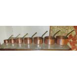 GRADUATED COPPER PANS, a set of seven, the largest 20cm diam and another set of four.