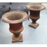 URNS, a pair, iron with rusty finish, each 50cm H x 40cm W.