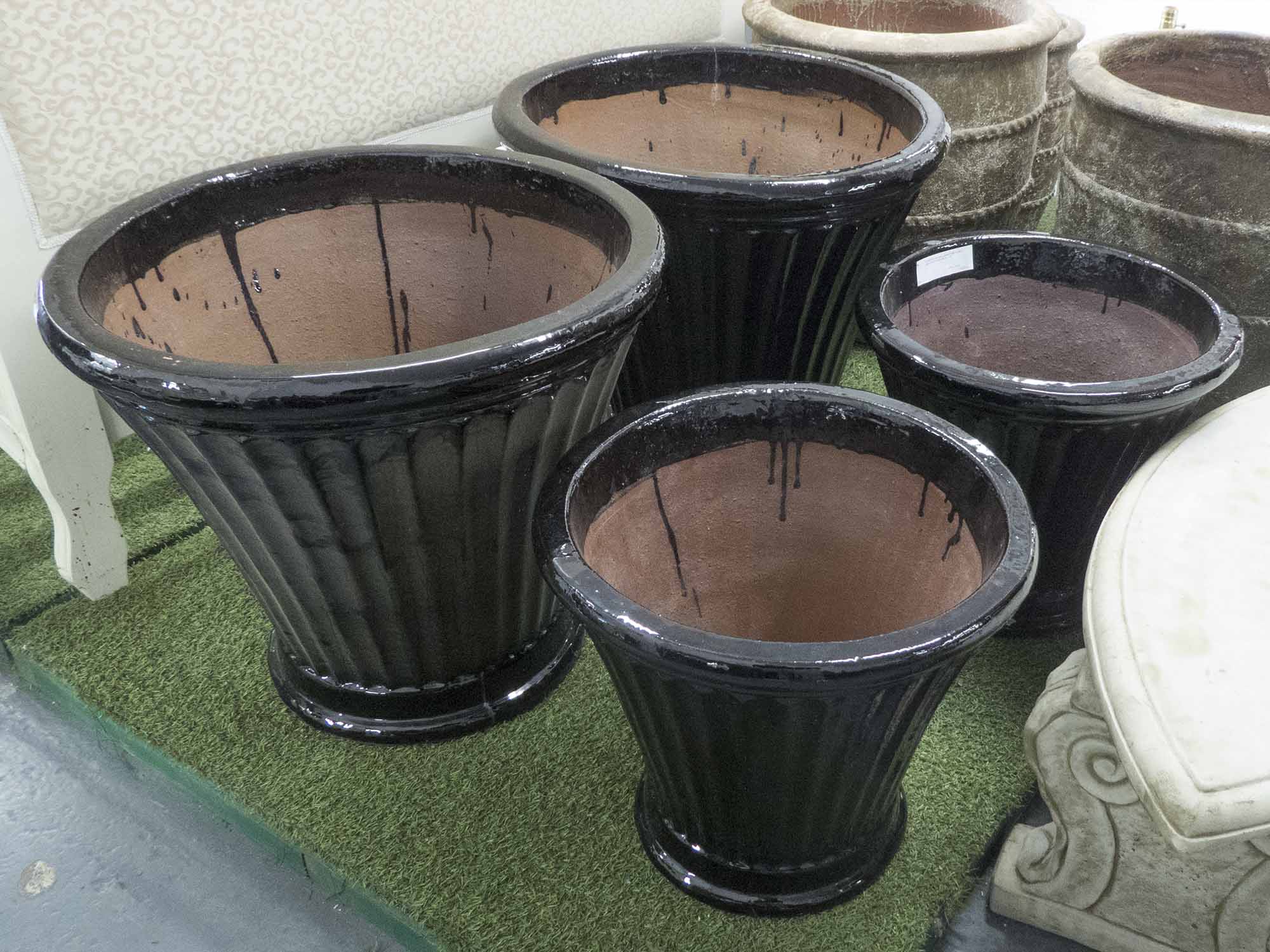 PLANTERS, two pairs, glazed fluted in black, large 57cm H, small 46cm H.