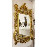WALL MIRROR, Georgian style gilt with an elaborate frame enclosing a bevelled plate,