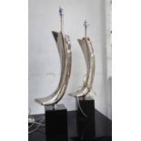 LAMPS, a pair, curved metal on black bases, 78cm H.