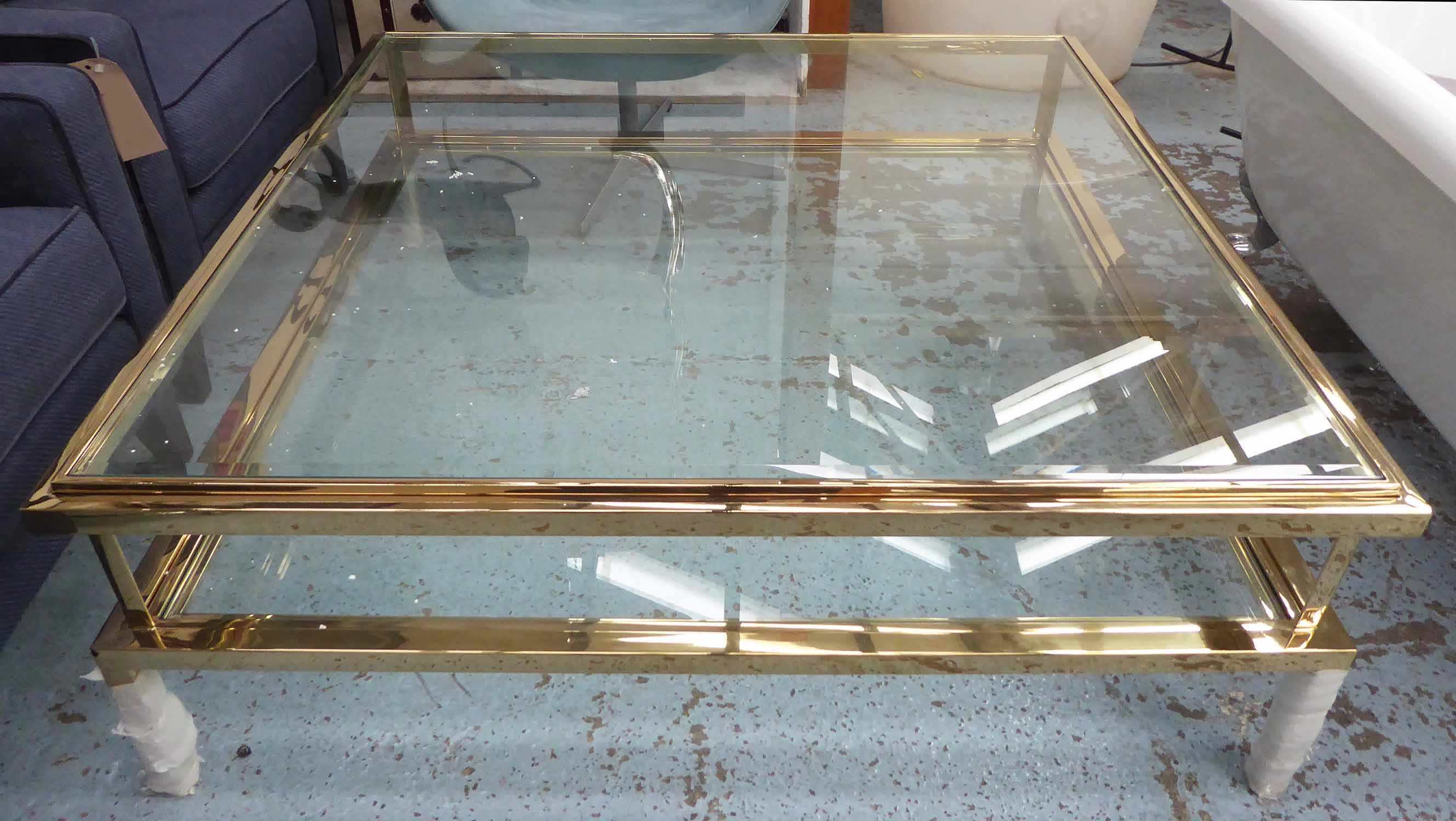 LOW TABLE, square form, having a bevelled glass inset top with lower tier in a brass frame,