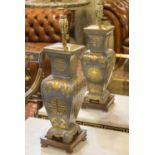 LAMPS, a pair, of Japanese style grey metal and raised gilt metal figurative detail on wooden bases,