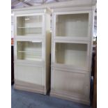 LIBRARY BOOKCASES, a pair, contemporary white painted with locking doors and lights,