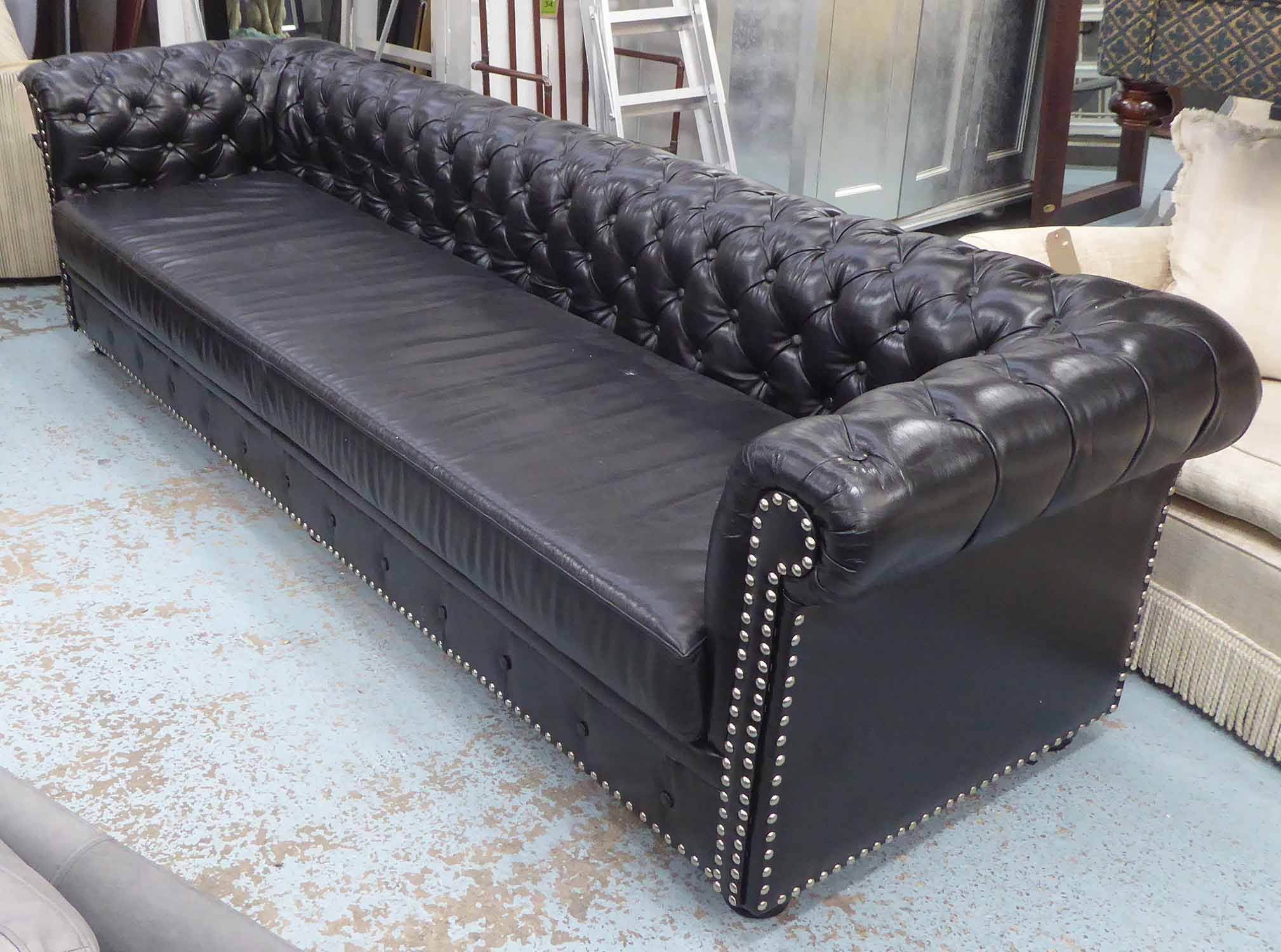 CHESTERFIELD STYLE SOFA, of large proportions, in black buttoned back leather with chrome studs,