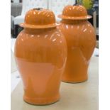 VASES, a pair, Chinese orange glazed ceramic with lids, 51cm H.