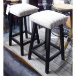 BARSTOOLS, a pair, with cream padded fabric tops on square ebonised supports, 40cm x 40cm x 65cm H.