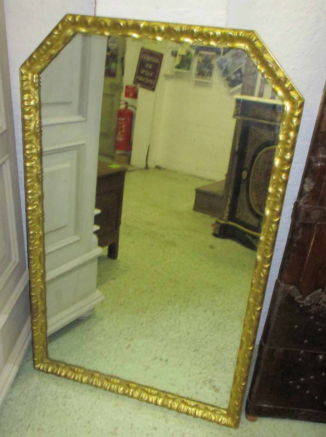 WALL MIRROR, 19th century Continental giltwood with leaf decorated canted corner frame,