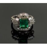 A FINE EMERALD AND DIAMOND CLUSTER RING, mounted in platinum, weight of emerald 1.25 carats.