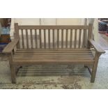 GARDEN BENCH, weathered teak of slatted construction with flat top arms, 152cm W.