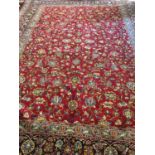 FINE PERSIAN TABRIZ CARPET, 412cm x 310cm, of scrolling vines and palmettes on ruby field.