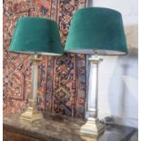 TABLE LAMPS, a pair, gilt coloured, each with a green shade, 74cm H.