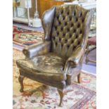 WING ARMCHAIR, Georgian style in buttoned brown leather with seat cushion, 108cm H x 83cm W.