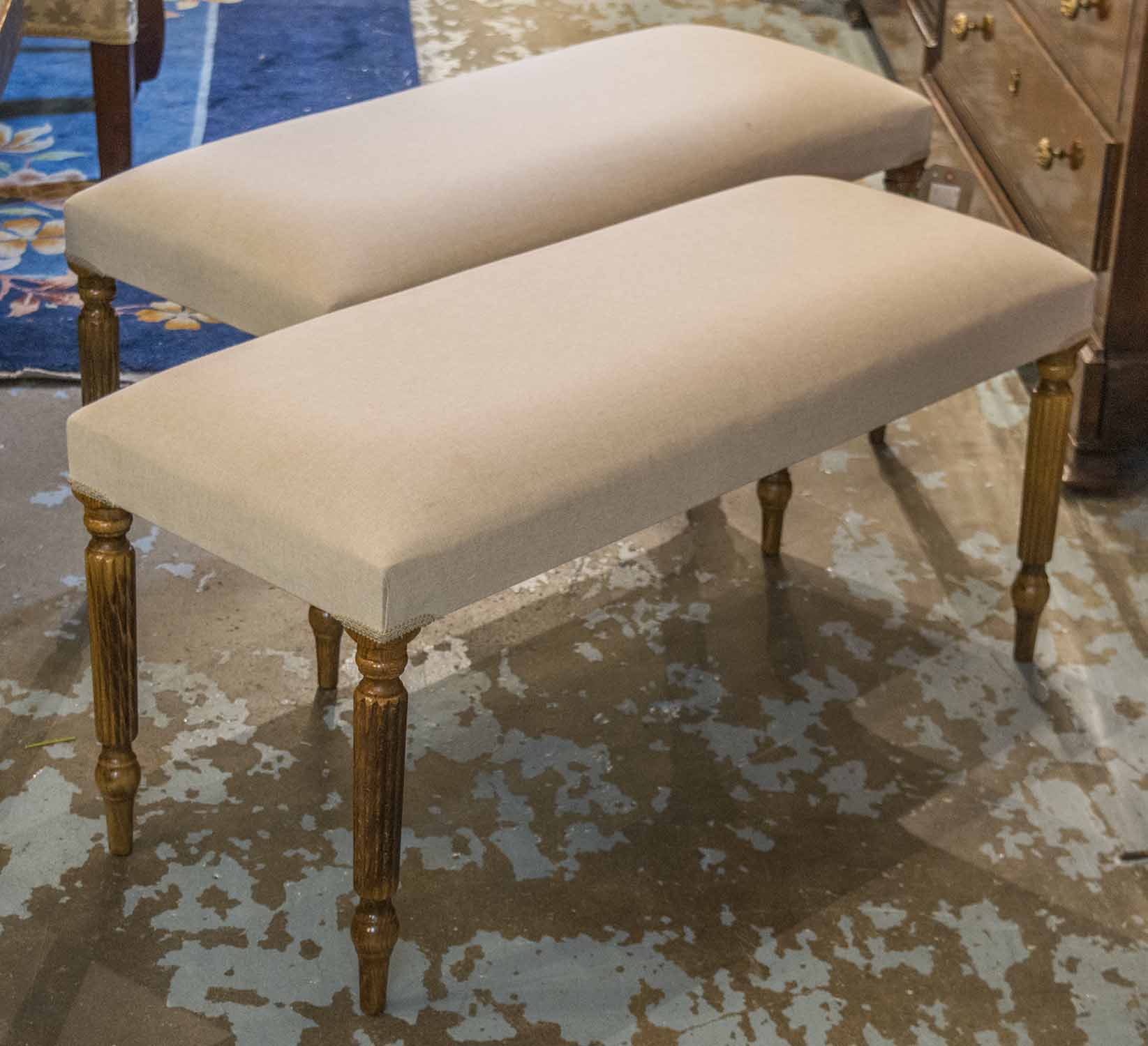 STOOLS, a pair, each with a rectangular beige upholstered top on reeded turned supports,