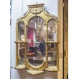 WALL MIRROR, 19th century, giltwood and gesso, with multiple plates and bowed shelves,