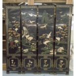 SCREEN, Chinese, of four panels, in black lacquer with relief decoration of cranes,