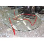 OCCASIONAL TABLE, oval glass top on red metal supports, 109cm W x 89cm D x 31cm H.