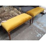 FOOTSTOOLS, a pair, in a gold velvet fabric, on turned fluted supports, 98cm x 39cm x 46cm H.