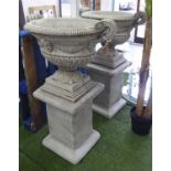 URNS, a pair, on stands, classical style in reconstituted stone, 119cm H.