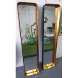 WALL MIRRORS, a pair, black with gilt detail and rounded corners, 30cm x 130cm H x 7cm D.