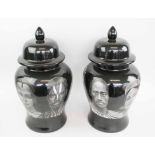 TWO BLACK FORNASETTI STYLE TEMPLE JARS.