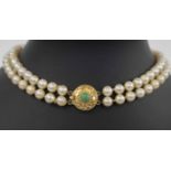 A TWO ROW CULTURED PEARL NECKLACE, with a circular eighteen carat gold clasp.