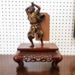 A FINE JAPANESE MEIJI PERIOD BRONZE AND GILDED BRONZE FIGURE OF A SAMURAI WARRIOR, on a wood stand,